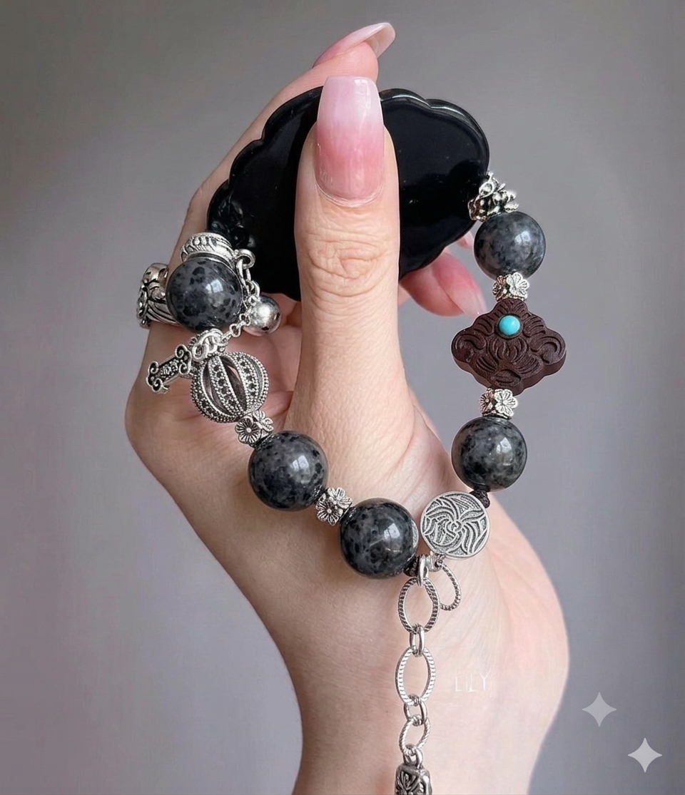 Volcanic Flow bracelet showing labradorite beads, carved wood clover charm, and silver filigree details